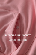 Close-up of a pink fabric garment showing a hidden snap pocket with white text overlay reading 'HIDDEN SNAP POCKET' and 'Locked-In Storage'.